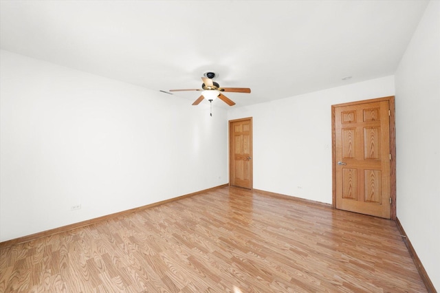 spare room with ceiling fan, baseboards, and light wood-style flooring