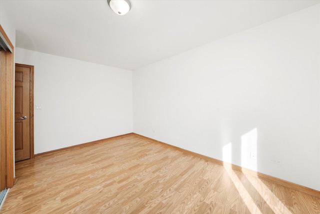 spare room with light wood-style floors and baseboards