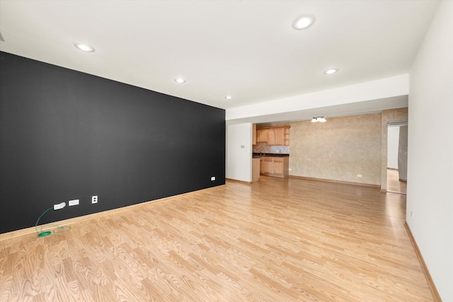 unfurnished living room featuring recessed lighting, baseboards, and light wood-style floors