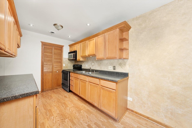 kitchen with dark countertops, light wood-style floors, light brown cabinetry, and range with electric stovetop