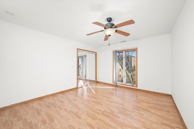 spare room with light wood-type flooring, baseboards, and ceiling fan