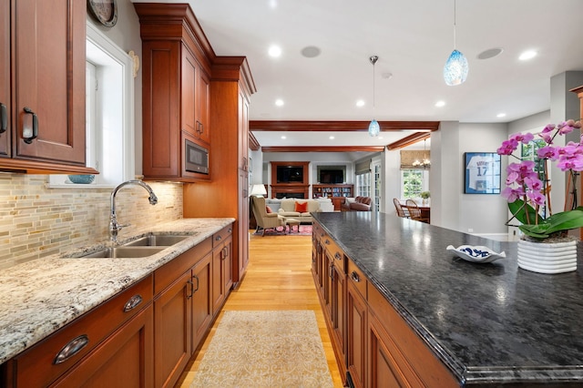 2855 Sheridan Pl, Evanston, IL 60201 - kitchen featuring open floor plan, light wood-style floors, tasteful backsplash, pendant lighting, and brown cabinets