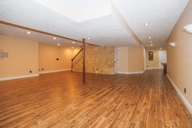 1208 Broad Creek Rd, Bloomington, IL 61704 - finished below grade area with a textured ceiling, light wood finished floors, recessed lighting, stairs, and baseboards