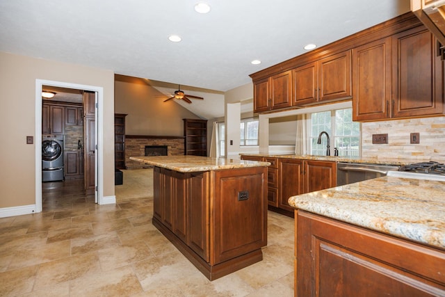 1208 Broad Creek Rd, Bloomington, IL 61704 - kitchen with ceiling fan, washer / dryer, dishwasher, a fireplace, and light stone counters