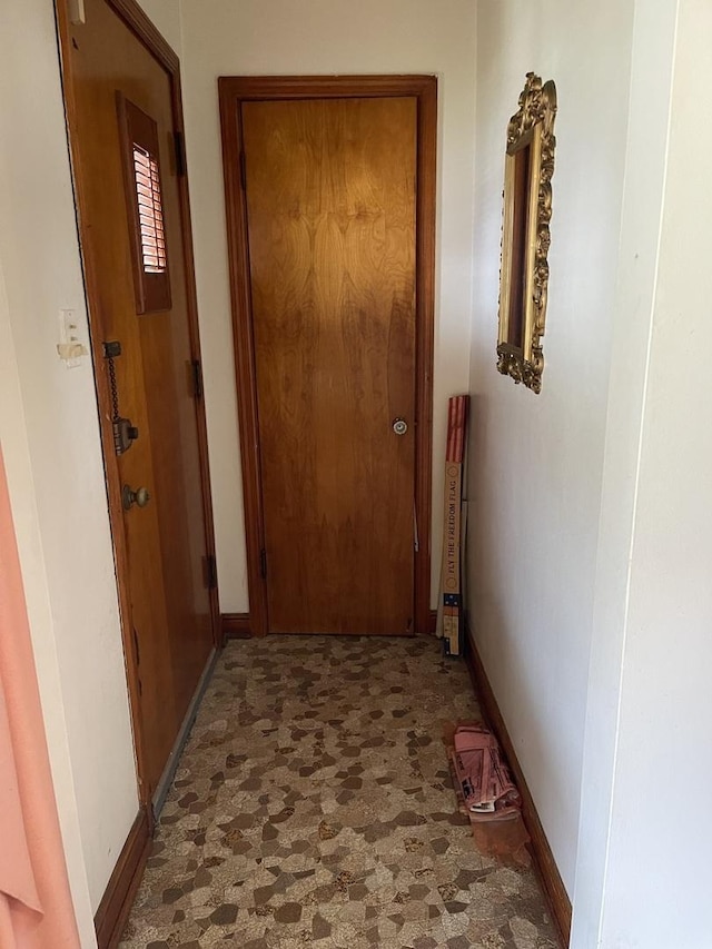 hallway with tile patterned floors and baseboards