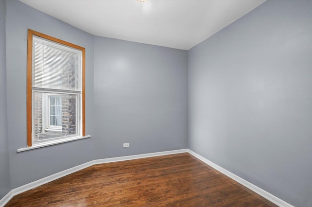 empty room featuring dark wood finished floors and baseboards