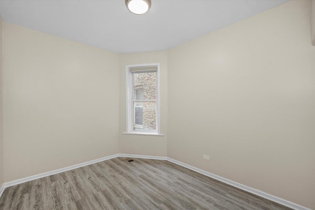 unfurnished room with baseboards and wood finished floors