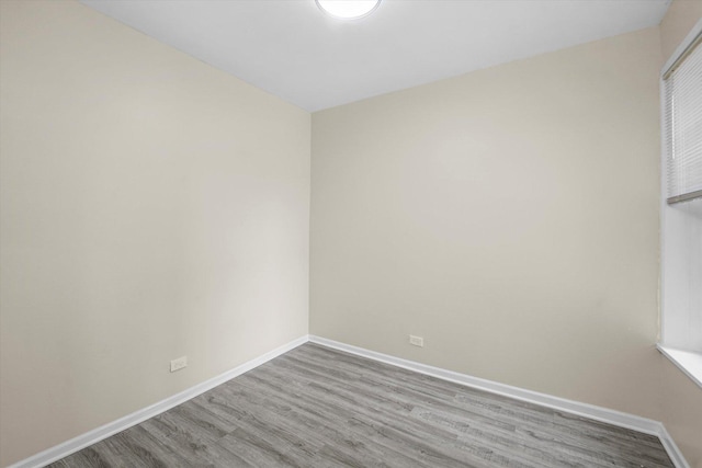 empty room featuring baseboards and wood finished floors