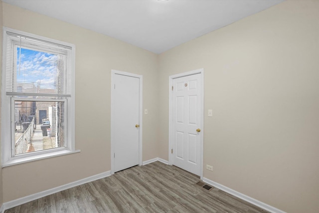 interior space featuring visible vents, wood finished floors, and baseboards