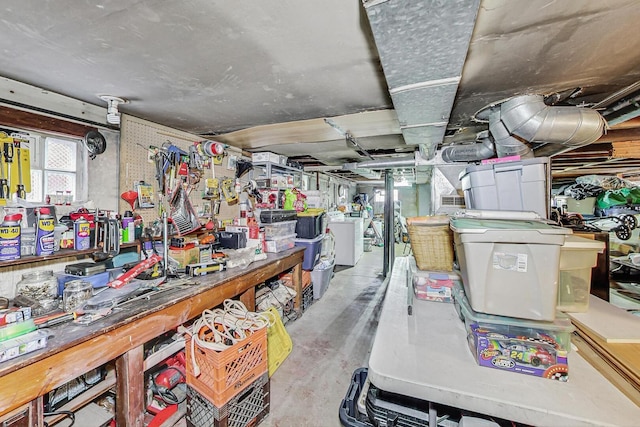 misc room featuring a workshop area, washer / clothes dryer, and concrete flooring