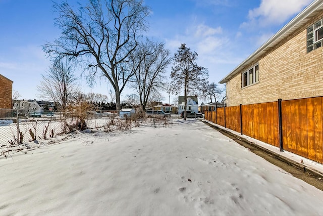 yard layered in snow featuring fence