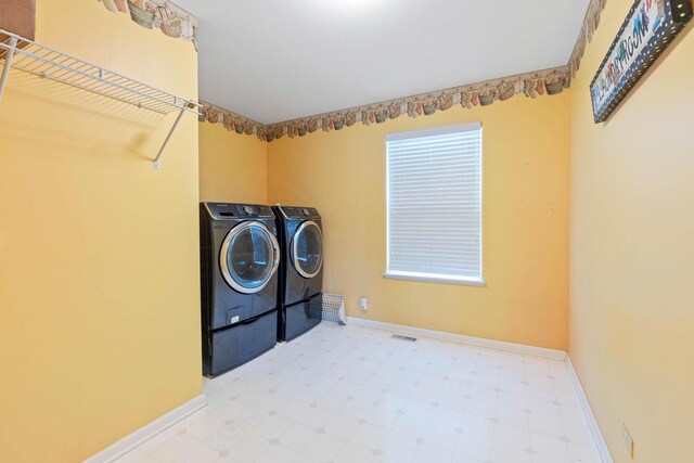 2668 Bull Run Dr, Aurora, IL 60503 - laundry area featuring tile patterned floors, baseboards, washing machine and clothes dryer, and laundry area