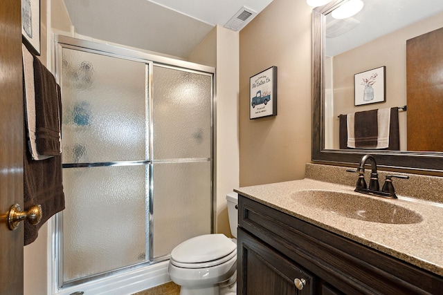 bathroom featuring vanity, toilet, visible vents, and a stall shower