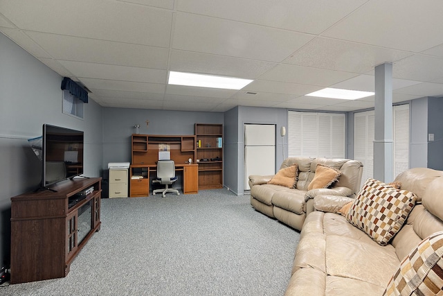 carpeted living area with a paneled ceiling