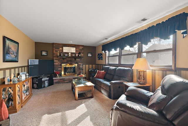 carpeted living room with visible vents, a wainscoted wall, and a fireplace