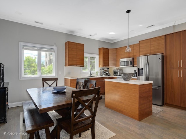 kitchen featuring light countertops, brown cabinetry, visible vents, and appliances with stainless steel finishes