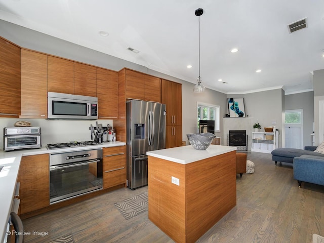 kitchen featuring visible vents, a kitchen island, open floor plan, stainless steel appliances, and brown cabinetry