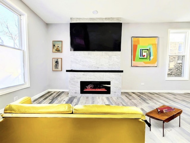 unfurnished living room with baseboards, wood finished floors, and a tile fireplace