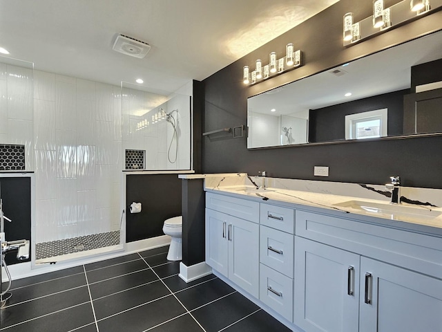 full bathroom featuring a walk in shower, toilet, double vanity, tile patterned floors, and a sink