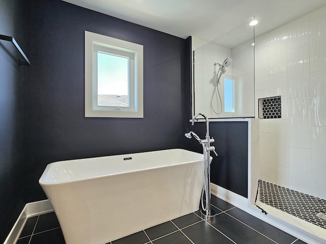 full bathroom featuring tile patterned floors, a freestanding tub, baseboards, and a walk in shower