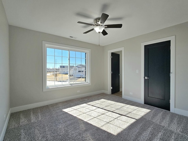 unfurnished bedroom with visible vents, ceiling fan, carpet, and baseboards