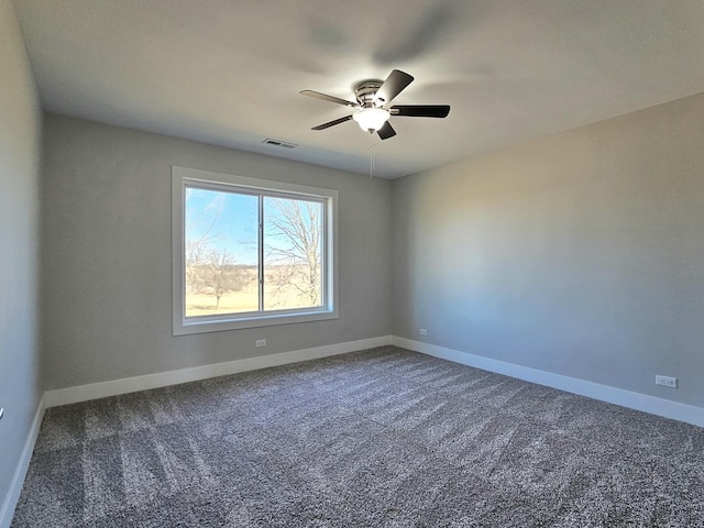 carpeted spare room featuring visible vents, a ceiling fan, and baseboards