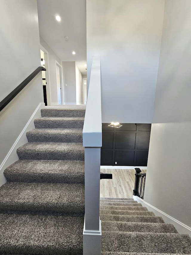 stairs featuring recessed lighting and wood finished floors