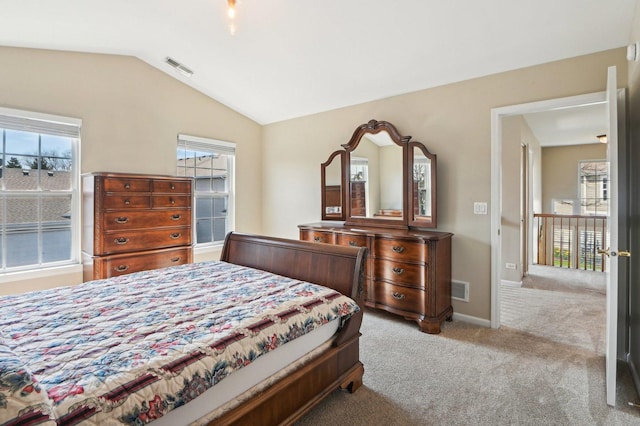 carpeted bedroom with lofted ceiling, visible vents, and baseboards