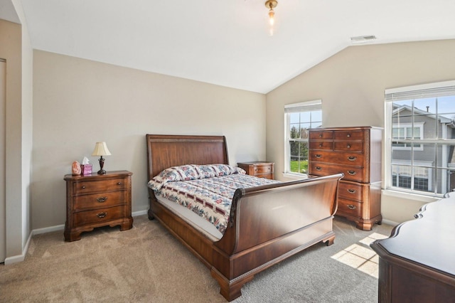 bedroom with light colored carpet, visible vents, vaulted ceiling, and baseboards