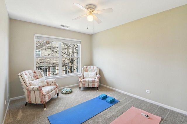 living area featuring visible vents, baseboards, a ceiling fan, and carpet floors