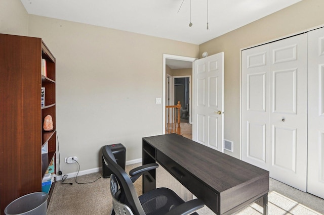 carpeted office space featuring baseboards and visible vents