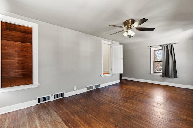 unfurnished room with visible vents, baseboards, and hardwood / wood-style flooring