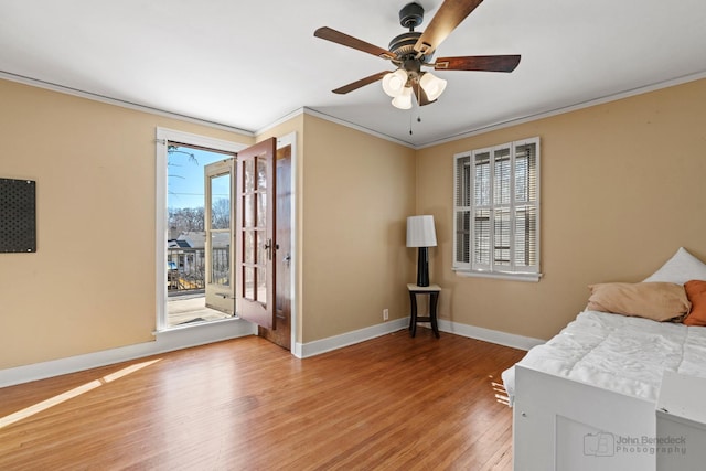 bedroom with ornamental molding, a ceiling fan, access to outside, wood finished floors, and baseboards