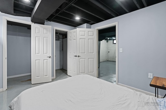 bedroom with baseboards and finished concrete floors