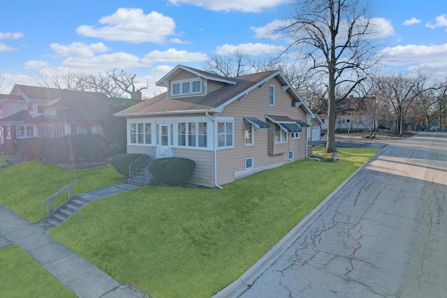 bungalow-style home with a front lawn, a chimney, and a shingled roof