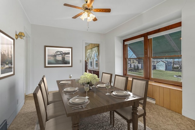 dining space with light carpet and a ceiling fan