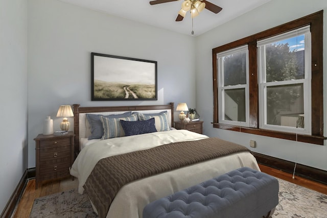 bedroom featuring ceiling fan, baseboards, and wood finished floors