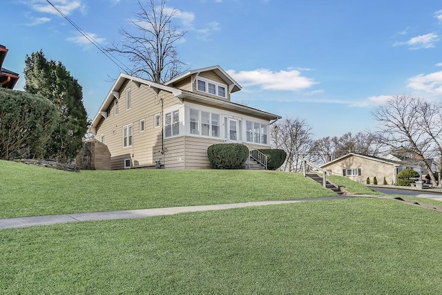 bungalow featuring stairs and a front lawn