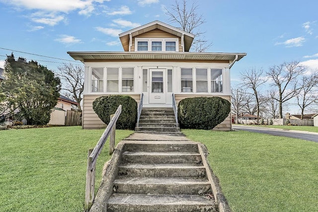 bungalow-style home featuring a front lawn and fence