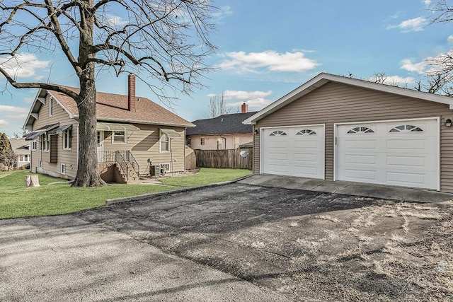 detached garage featuring fence