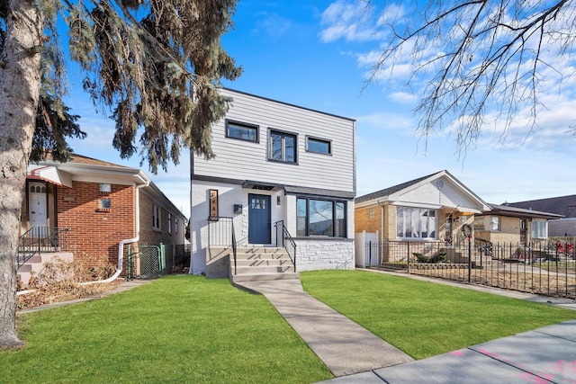 view of front of property with a front lawn, fence, and brick siding