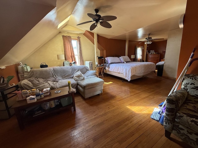 bedroom featuring a ceiling fan, radiator heating unit, lofted ceiling, and wood-type flooring