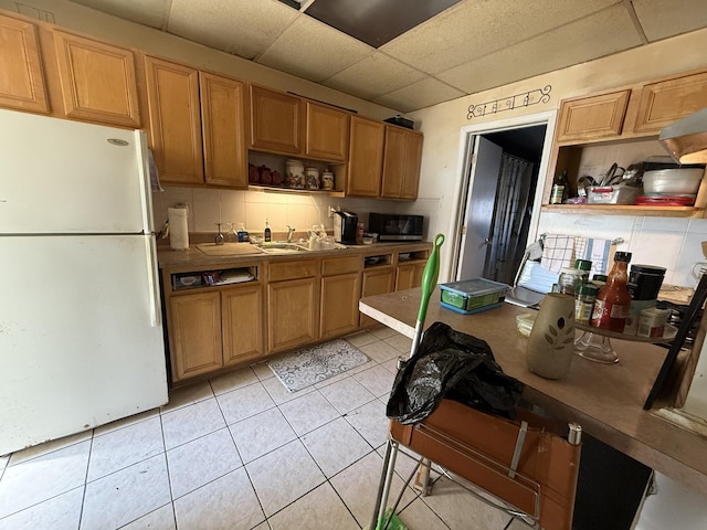 kitchen featuring tasteful backsplash, a drop ceiling, light tile patterned floors, freestanding refrigerator, and open shelves