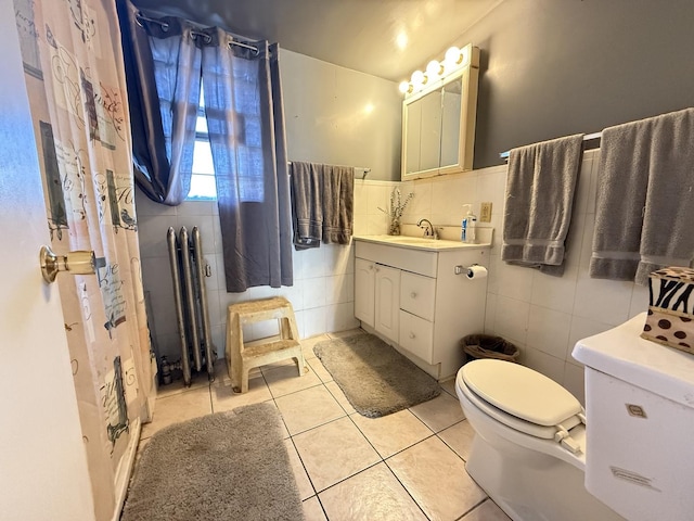 full bath with tile patterned flooring, tile walls, a wainscoted wall, toilet, and vanity