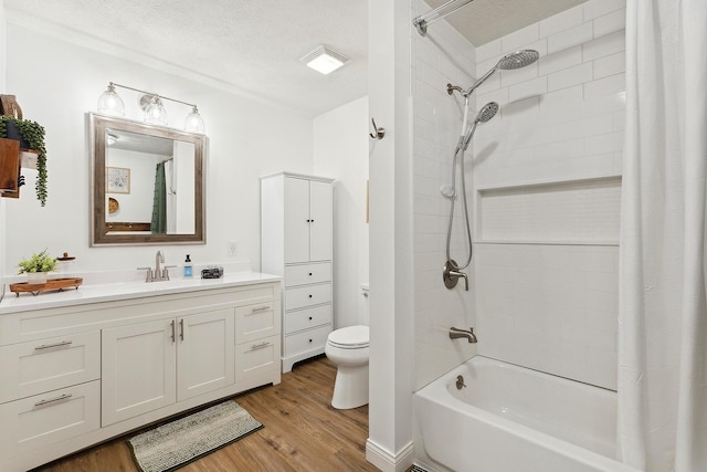 full bathroom with toilet, shower / tub combo with curtain, a textured ceiling, wood finished floors, and vanity