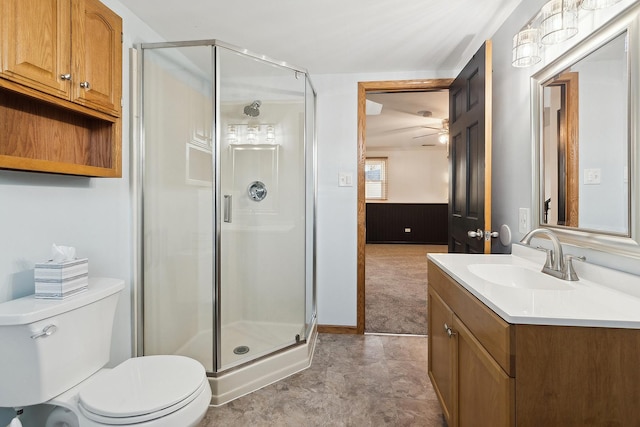 bathroom with vanity, toilet, ceiling fan, and a shower stall