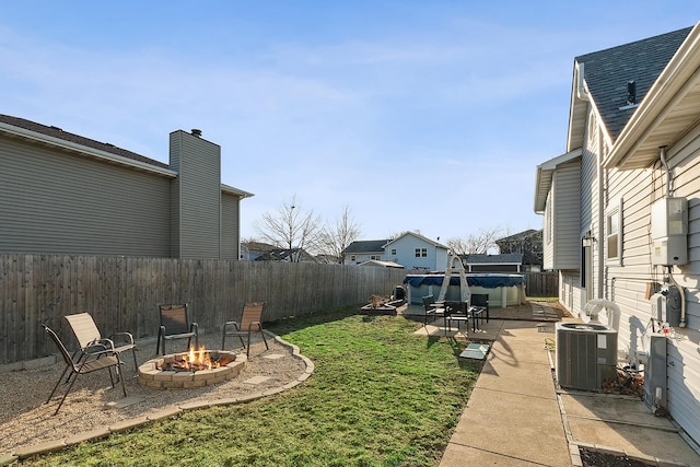 view of yard featuring a patio area, central air condition unit, an outdoor fire pit, and a fenced backyard