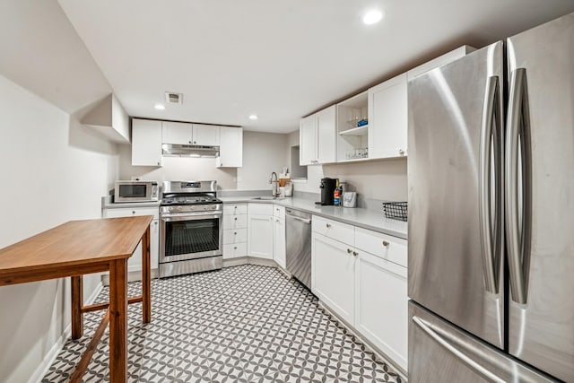 kitchen with visible vents, a sink, under cabinet range hood, stainless steel appliances, and open shelves