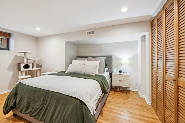 bedroom with visible vents, baseboards, a closet, and light wood finished floors