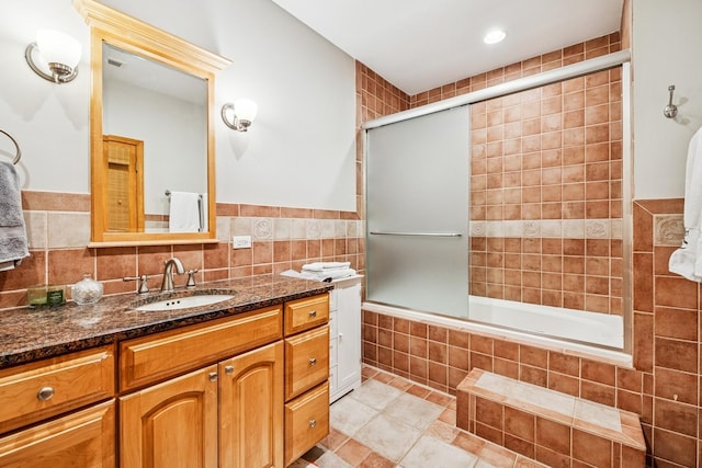 full bath with tiled shower / bath combo, vanity, tile walls, and tile patterned floors